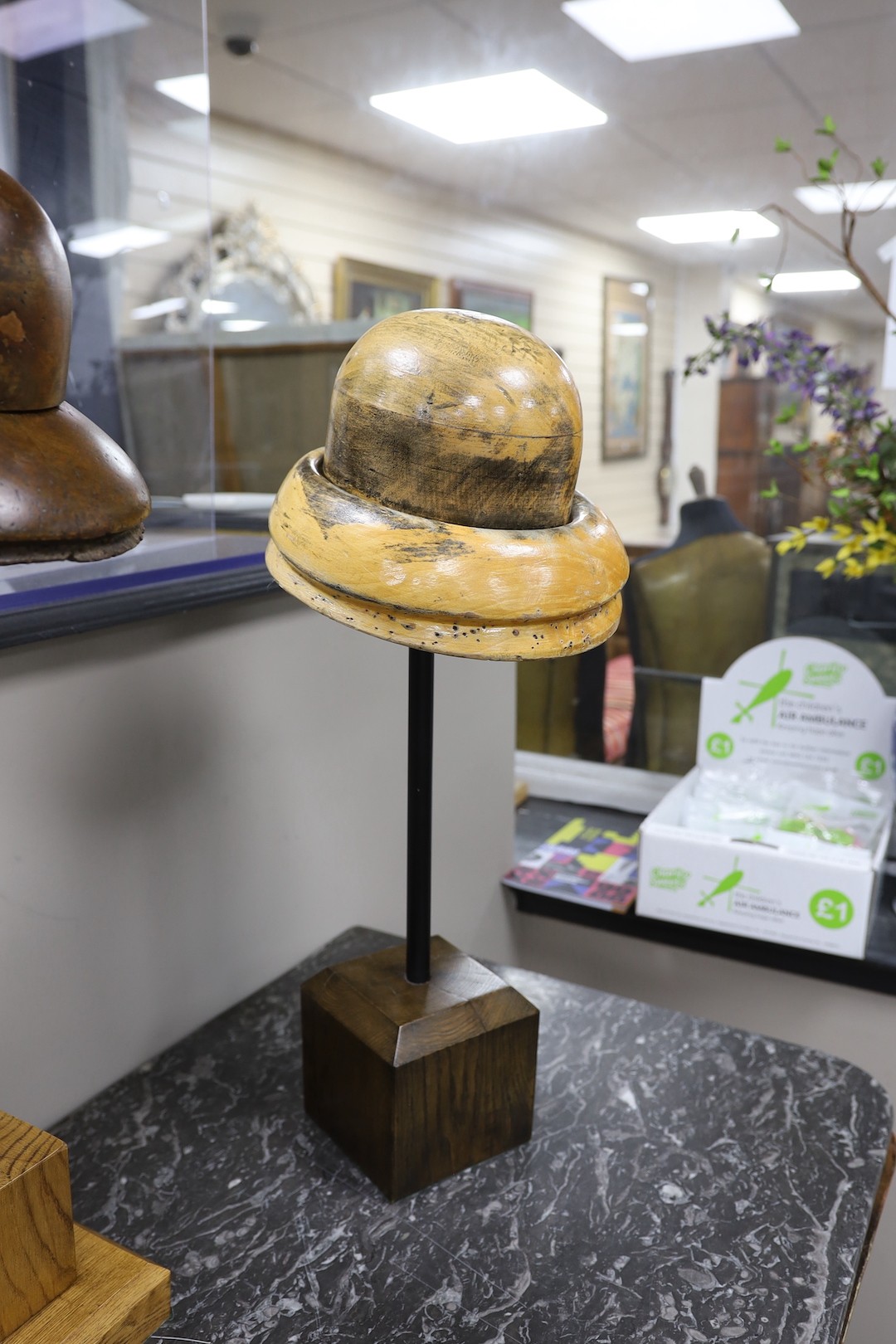 A group of three vintage milliner's hat-blocks, on stands